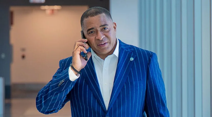 Un hombre con traje azul de raya diplomática hablando por teléfono